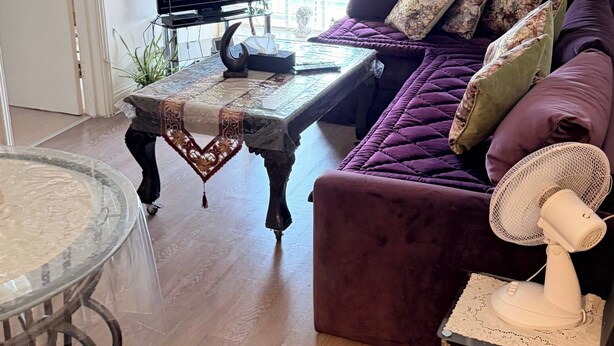 A living room with a sofa, a table, a television, and a plant. - Apartment Sleeps 6 with in Kilburn Lane (London)