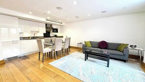 A modern living space with a dining area, kitchen, and seating area.