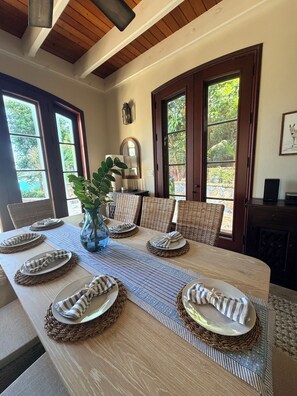 A dining table set with plates, napkins, and a vase. - VILLA AMOROSA: Upper Peter Bay Luxury Getaway w/ Ocean Views, Private Pool (St John)