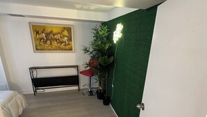 A room with a bed, a bench, a green wall, and a painting. - Bluffs suite retreat - beautiful cliffcrest leafy suburb moments from the beach! (Toronto)