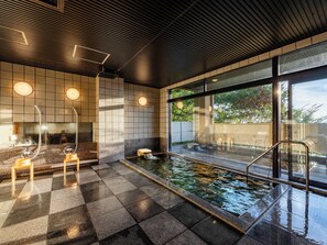 A modern indoor pool area with a checkered floor, a seating area, and a view through large windows. - SANEIKAKU (Matsumoto)