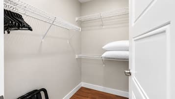 Um closet amplo com prateleiras brancas, um radiador e piso de madeira.
