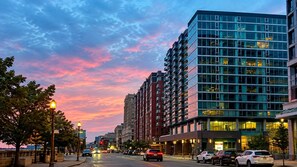 Edifício de vários andares com arquitetura moderna, fachada de vidro e uma série de varandas.