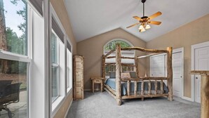 A bedroom with a four-poster bed, a ceiling fan, and large windows. - Chalet di Montagna ~ Spacious house in the pines (Mi-Wuk Village)