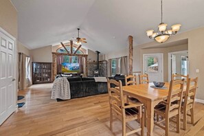 Amplia sala de estar con chimenea, mesa de comedor de madera y asientos cómodos.