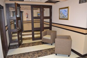 A hotel lobby with a reception desk, a fire extinguisher, and a framed map on the wall. - Assala (Dar Ben Abdellah)