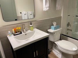 Un baño con lavamanos blanco, inodoro y zona de ducha.
