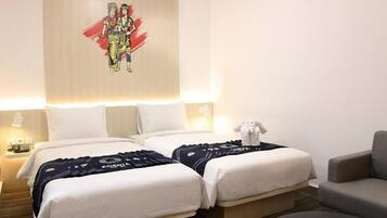 A hotel room with two beds, a sofa, a teddy bear, and a wall art piece.