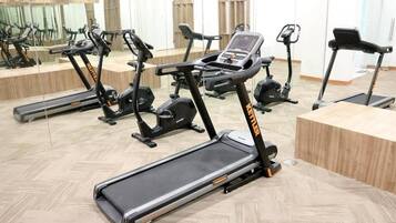 A gym with multiple exercise machines, including treadmills and elliptical trainers.