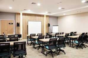 A conference room with multiple tables, chairs, a whiteboard, and a projector screen. - Cordia Banjarmasin (Banjarbaru)