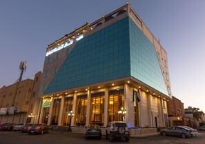 A hotel with a modern facade, large windows, and a prominent entrance. - Banan Hotel Suite (Tabuk)