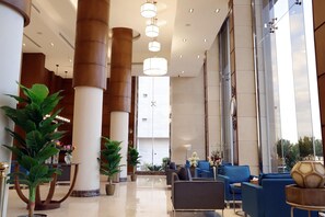 A spacious lobby with high ceilings, large columns, and modern seating arrangements. - Banan Hotel Suite (Tabuk)