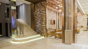 Un interior moderno con una escalera, un muro decorativo y un comedor.
