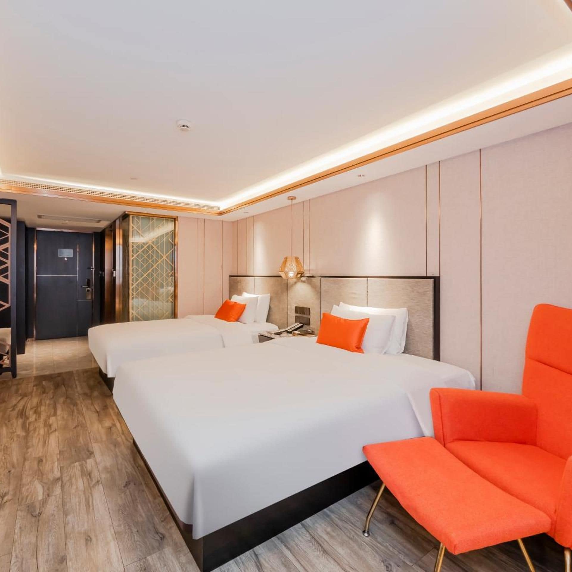 A hotel room with a large bed, two bedside tables, a nightstand, and a bright ceiling light.
