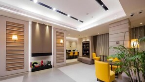 A modern living room with a sofa, a dining area, and a bookshelf. - Homeinn Plus Shanghai Zhangjiang Park (Shanghai)