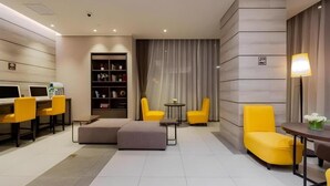 A modern hotel room with a desk, two yellow armchairs, a sofa, a bookshelf, and a large window with curtains. - Homeinn Plus Shanghai Zhangjiang Park (Shanghai)