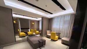 A modern hotel room with a sofa set, a coffee table, and a TV. - Homeinn Plus (beijing Zhongguancun Wudaokou (Beijing)