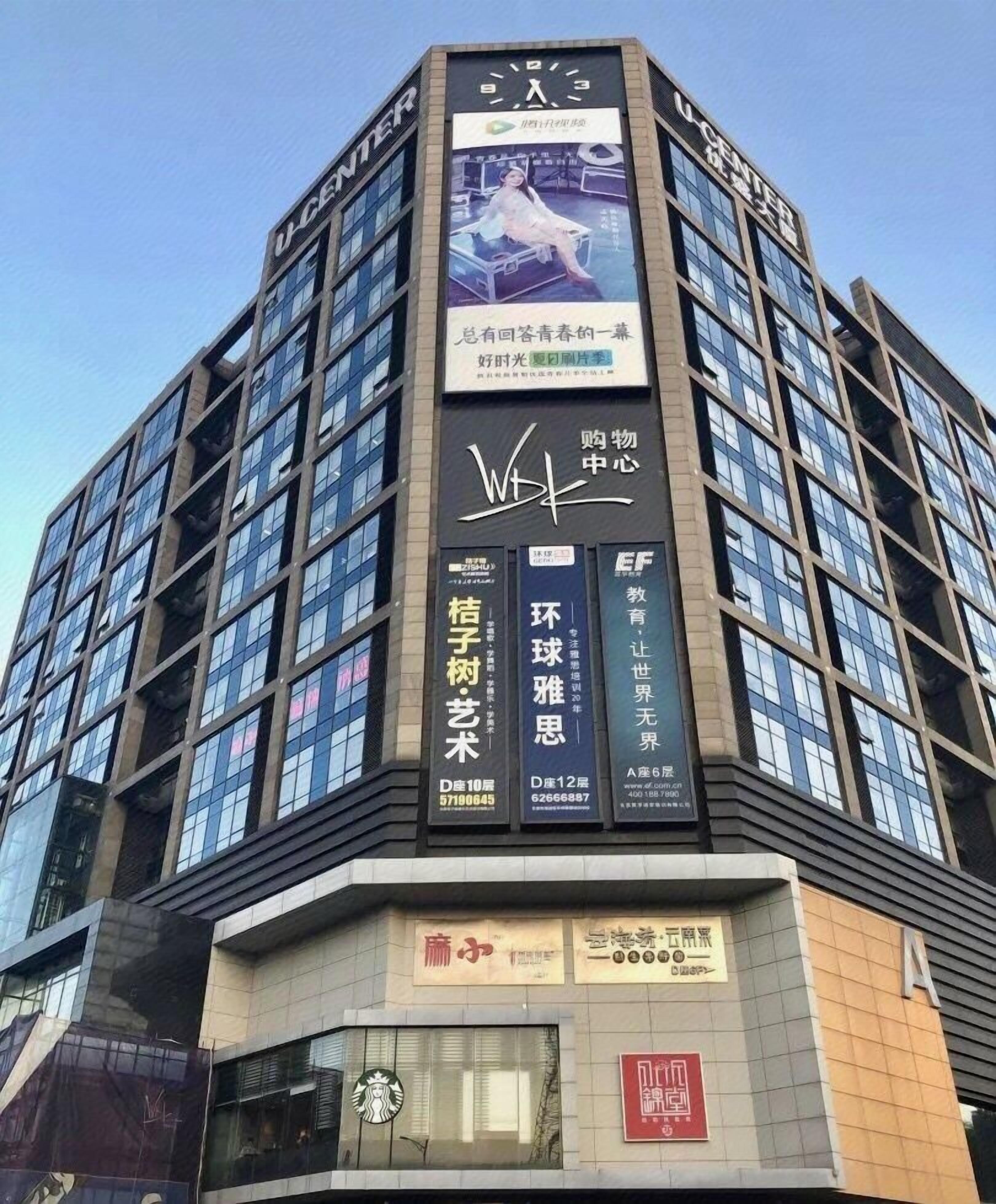 Un edificio de varios pisos con un letrero llamativo de un centro comercial.