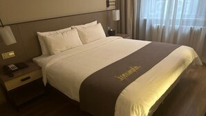 A hotel room with a bed, a bedside table with a phone, and a nightstand. - Homeinn Plus (beijing Zhongguancun Wudaokou (Beijing)