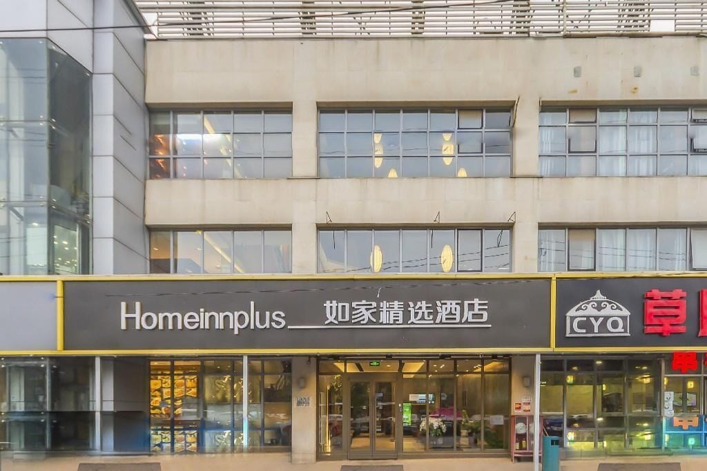 Un edificio con una fachada que dice 'Homeinnplus' y otro con un letrero 'CYQ'.
