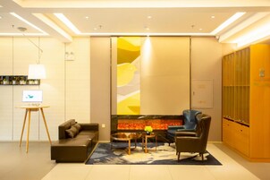 Una sala de estar moderna con sofá, sillón y chimenea.
