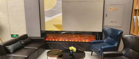 A modern lounge area with leather sofas, a round wooden coffee table, and a decorative vase.