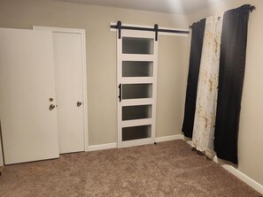 A room with a sliding door, a closet, and a curtain rod. - Spacious 4-bedroom house in pleasant Columbia with AC (Columbia)