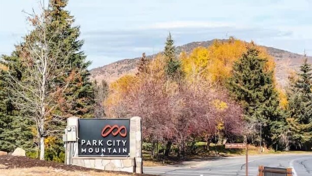 A sign for 'Park City Mountain' with a road and trees in the background. - Park City Condo – Pool, Hot Tub & Waffles (Park City)