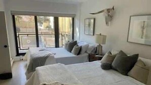 A hotel room with two beds, a balcony, and a cow skull decoration. - Park City Condo – Pool, Hot Tub & Waffles (Park City)