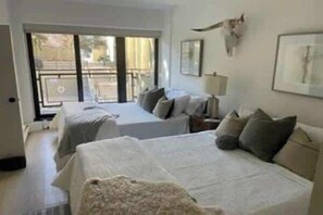 A hotel room with two beds, a balcony, and a cow skull decoration. - Park City Condo – Pool, Hot Tub & Waffles (Park City)