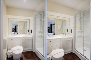 Une salle de bain moderne avec une douche à parois de verre, un lavabo blanc et des toilettes.