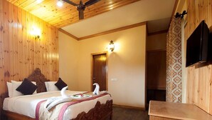 A wooden-paneled room with a bed, a desk, a wardrobe, and a television. - Tuskar S By Khurafati Nitin (Ramnagar)