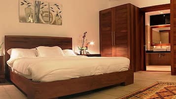 A bedroom with a bed, nightstands, a dresser, and a walk-in closet.