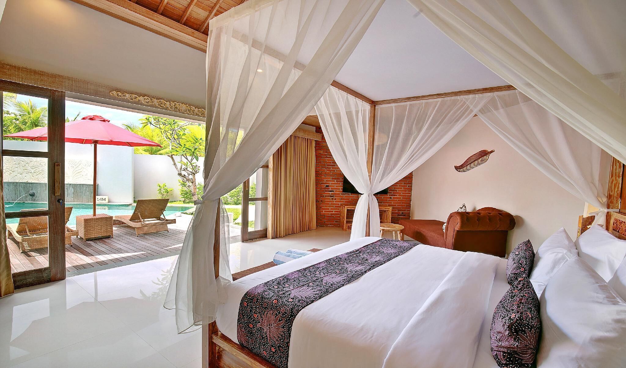 A bedroom with a large bed, a canopy, a view of a pool, and a dining area with outdoor seating.