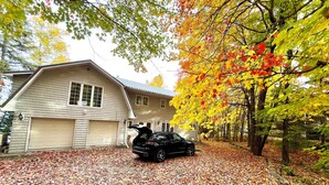Ett hus med ett garage och en bil parkerad framför.