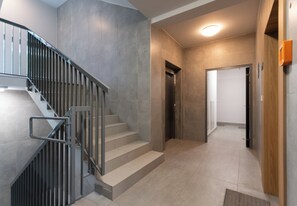 A modern interior with a staircase, a hallway, and a door leading to another room. - Cracow Novum Studio #124 (Kraków)