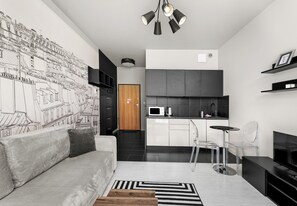 A modern apartment with a kitchen, a dining area, and a living room with a sofa and a coffee table. - Cracow Novum Studio #124 (Kraków)