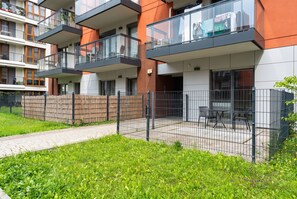 A multi-story residential building with balconies, a fenced outdoor area, and a pathway. - Cracow Novum Studio #124 (Kraków)