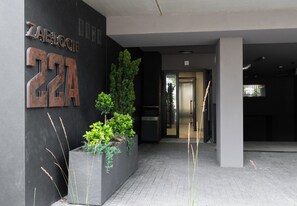Ein moderner Gebäudeeingang mit einem großen Schild, auf dem 'ZABLOCH 22A' steht.