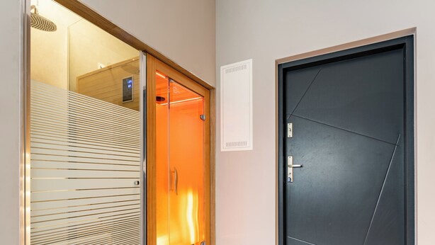 A modern hotel room with a sliding glass door, a dark door, and a light switch on the wall. - Willa 28D Lakeside Retreat Łączyno (Łączyno)
