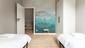 A room with two beds, a wooden floor, and a wall with a forest mural. - Willa 28D Lakeside Retreat Łączyno (Łączyno)
