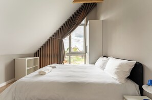 Une chambre à coucher avec un lit, une fenêtre et une vue sur l’extérieur.