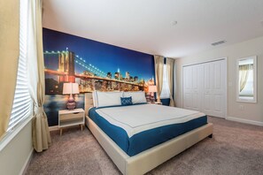 Hotelkamer met een groot bed, nachtkastje, lamp en een stadsgezicht muurschildering.
