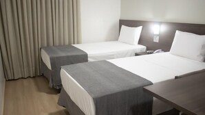 Ein Hotelzimmer mit zwei Betten, einem Nachttisch und einem Telefon.