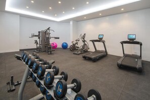A gym with exercise equipment, treadmills, and dumbbells. - The Belamy House (Makati)