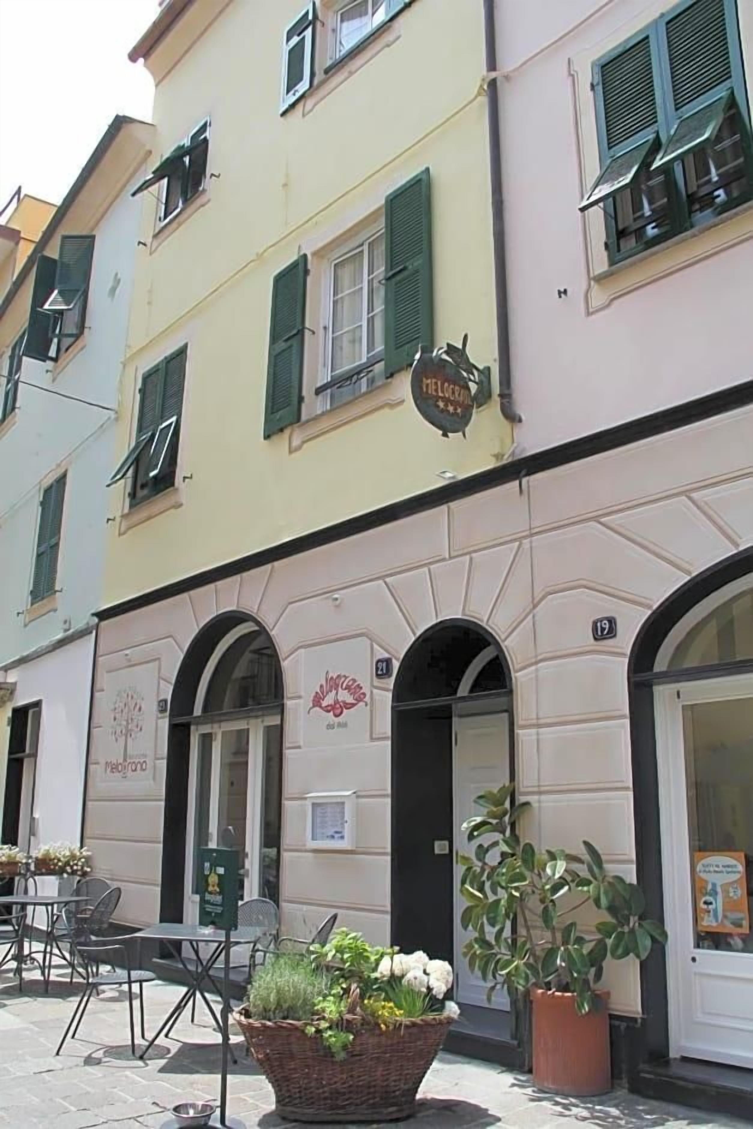 Un edificio con un cartello che recita 'MELOCEMMA' e il numero '19' sopra l'ingresso.