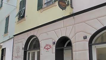 Un edificio con un cartello che recita 'MELOCEMMA' e il numero '19' sopra l'ingresso.