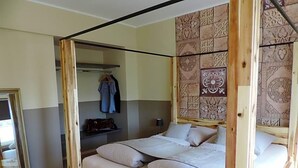 A single bed with a wooden frame and a headboard with a patterned design. - Hotel Sandmanns Am Dom (Cologne)