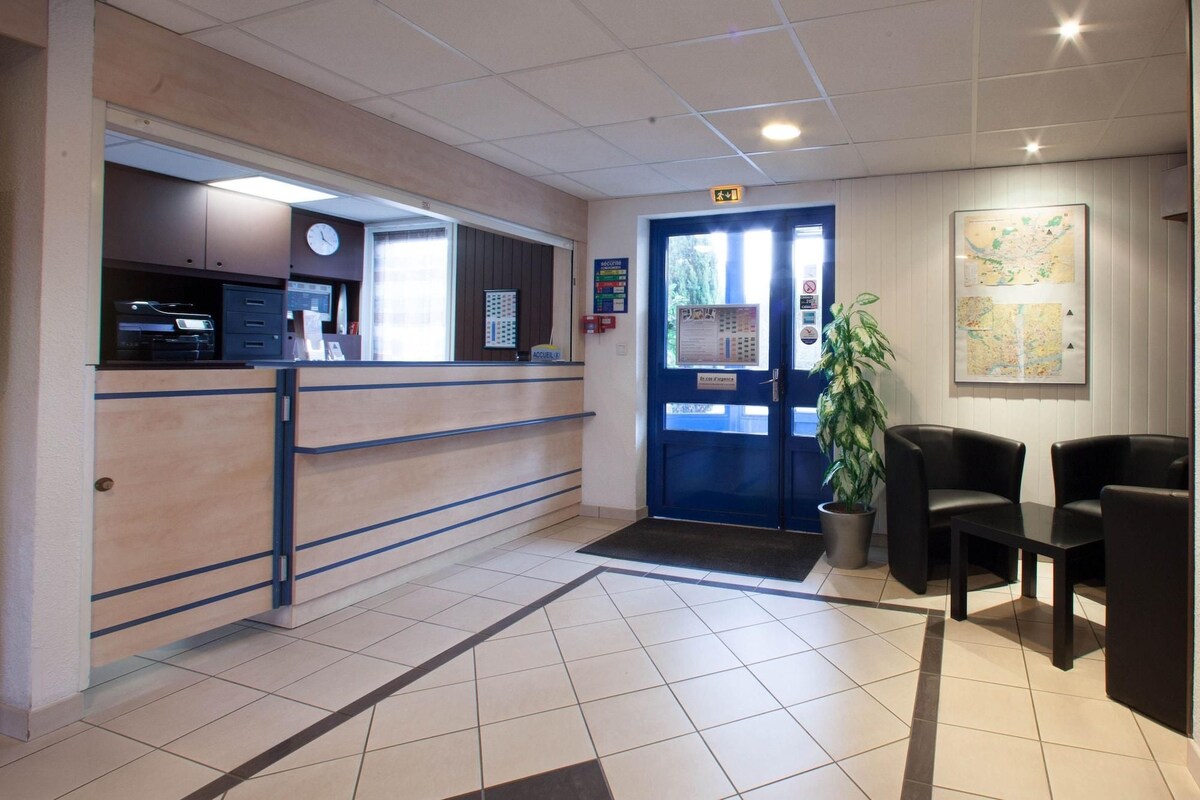 A reception area with a blue door, a reception desk, a clock, and a map on the wall.