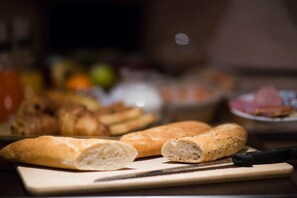A cutting board with a knife and several loaves of bread. - Hã´tel Akena Nantes (Sainte-Luce-sur-Loire)
